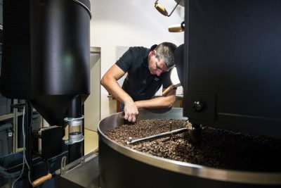 a fő pörkölő éppen ellenőrzi a pörkölt kávét